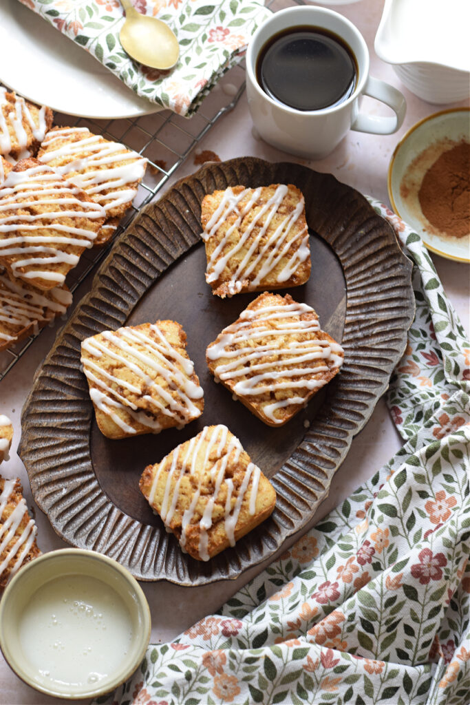 Cinnamon cake squares on a wooden tray.