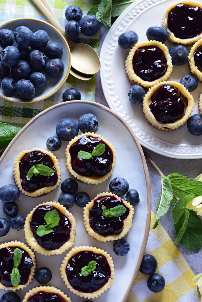 Mini blueberry cheesecakes on serving dishes.