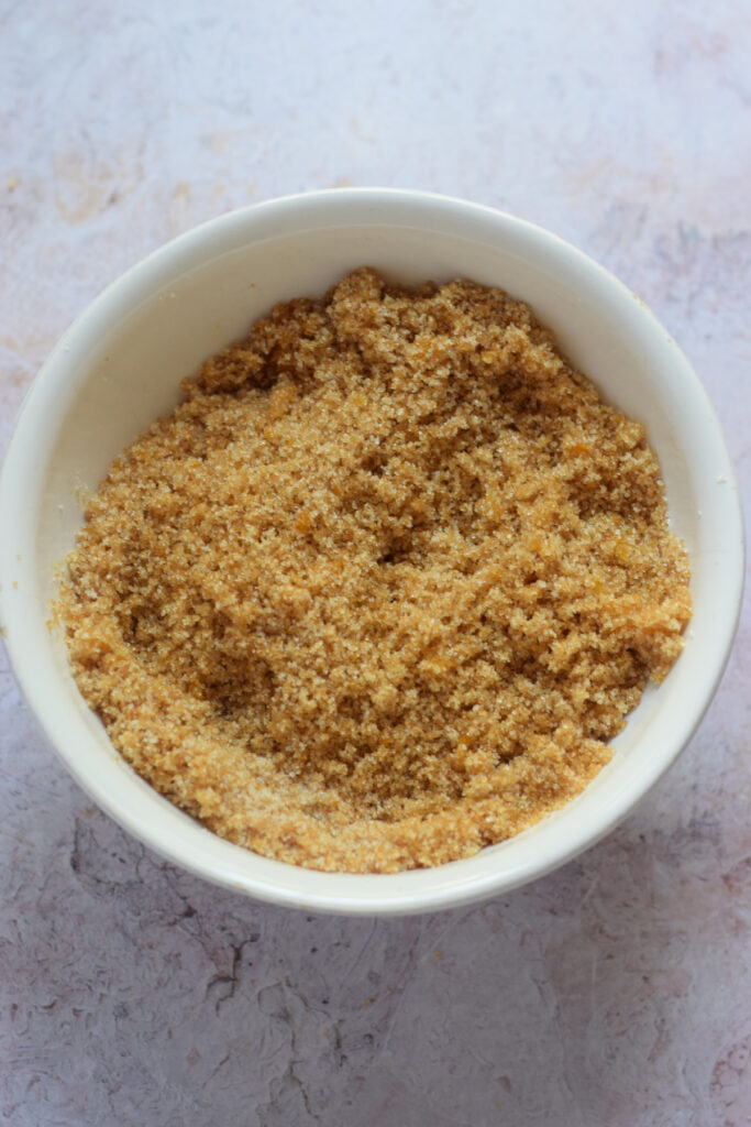 Sugar in a bowl with orange zest.