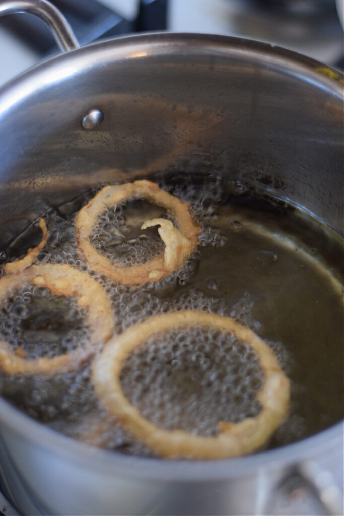 Cooking onion rings in a saucepan.