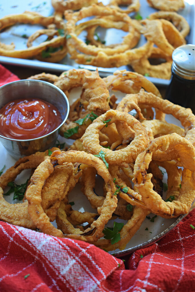 Beer battered onion rings with ketchup on the side.