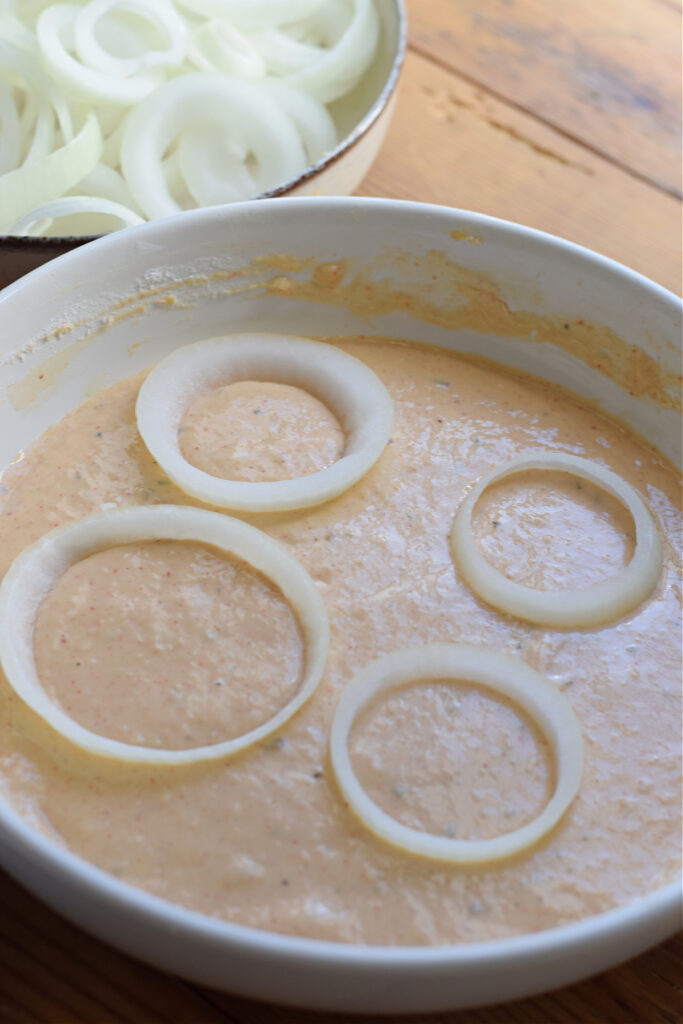 Coating onion rings in batter.