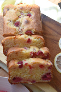 a raspberry lemon loaf cake on a wooden board