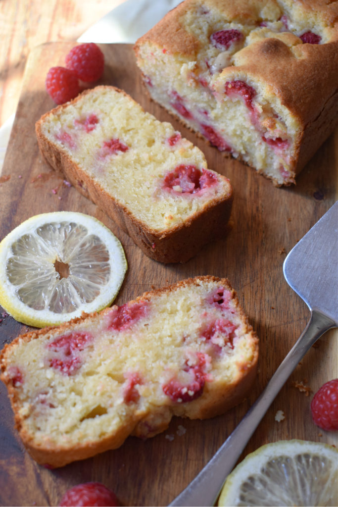 Raspberry Lemon Loaf Cake on a board with lemon slices