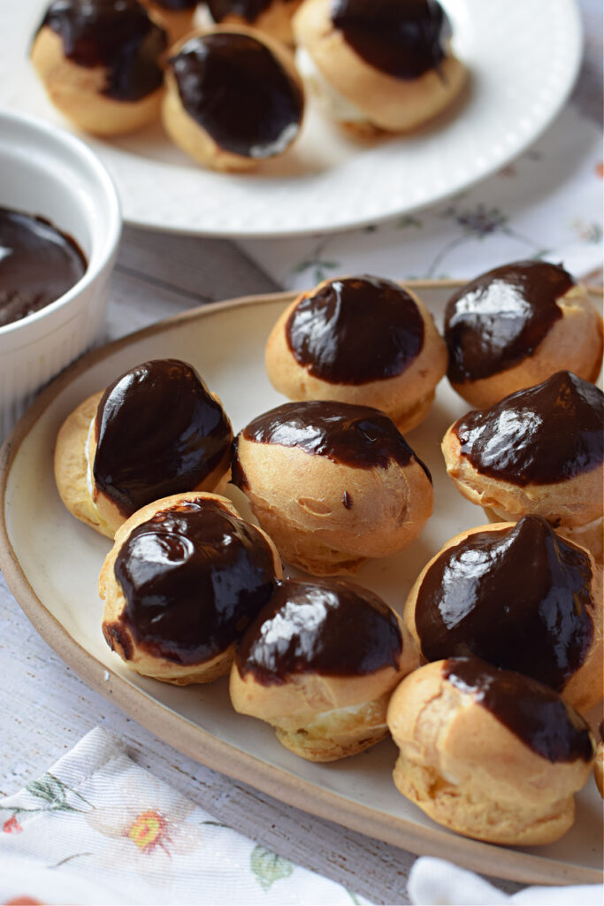 Close up of profiteroles with chocolate on a plate.