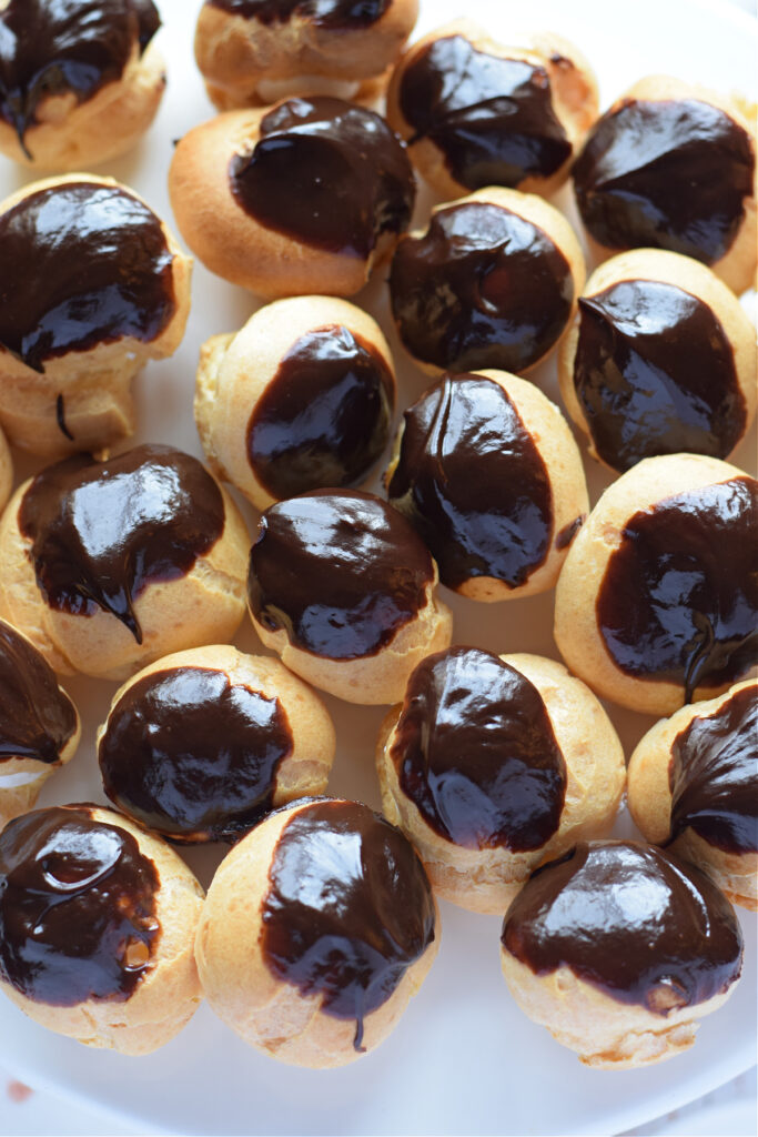 Close up of profiteroles with cream and chocolate.
