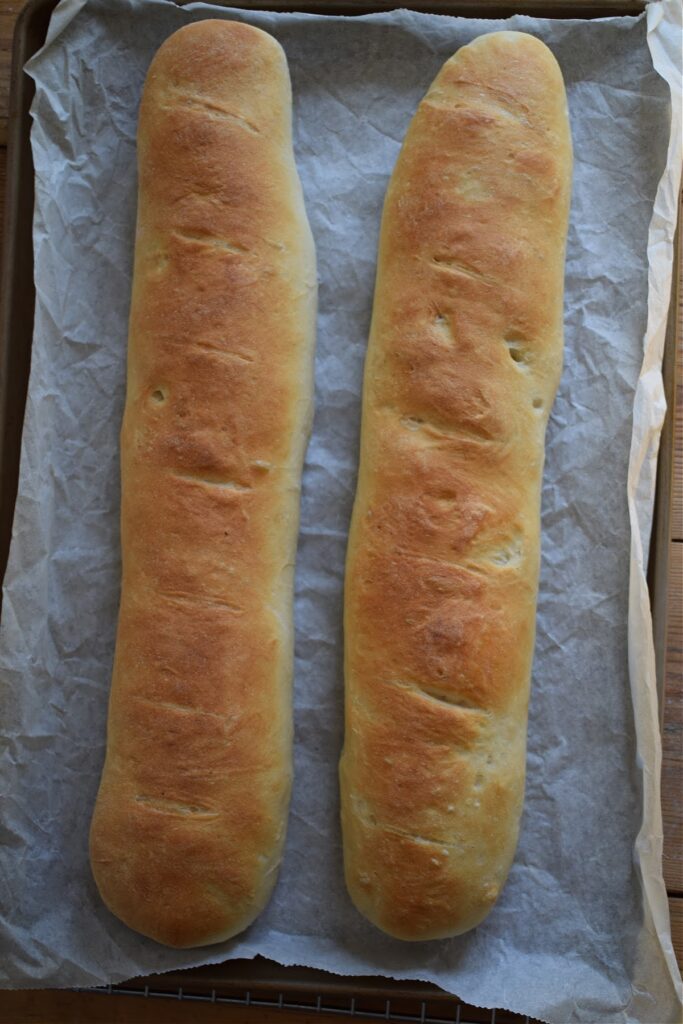Fresh baked baguette bread on a tray.