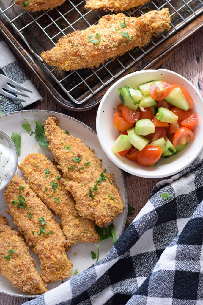 Baked cajun chicken tenders with a vegetable salad.