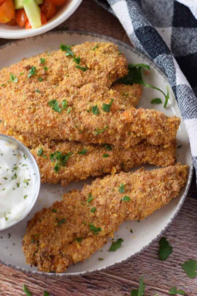 Baked cajun chicken tenders on a plate.