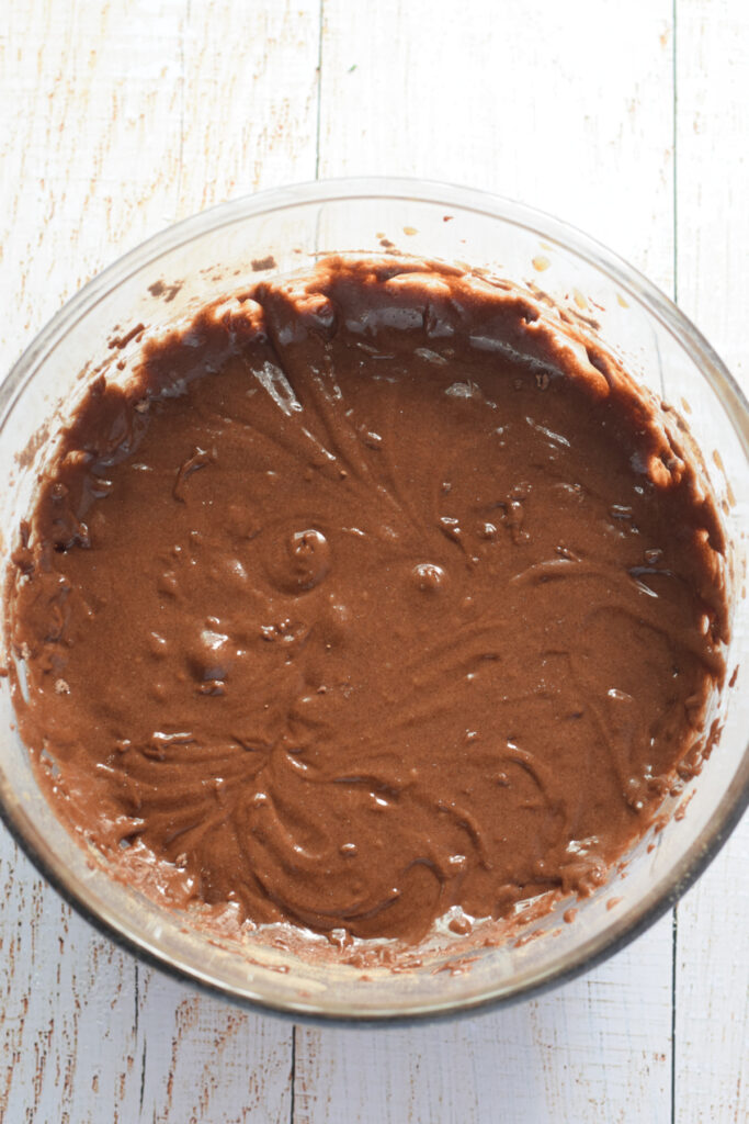 Chocolate cookie dough in a glass bowl.