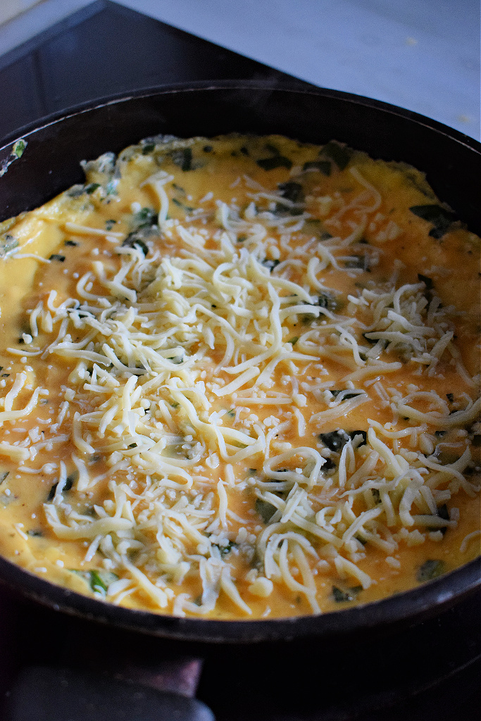 Mozarella and basil omelette cooking