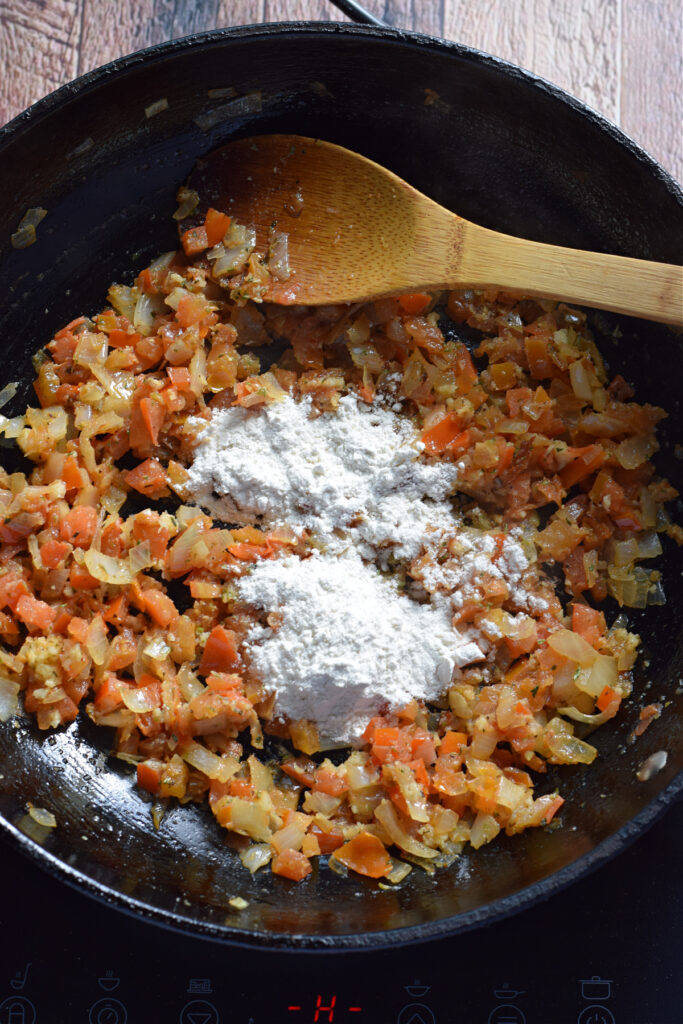 Adding flour to a skillet.