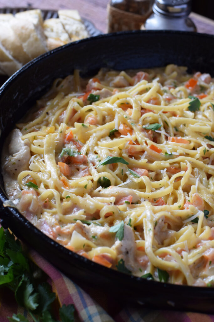Close up of creamy chicken and pasta in a skillet.