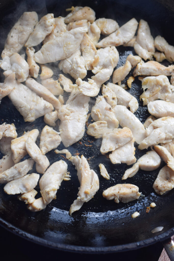 Cooking chicken in a skillet.