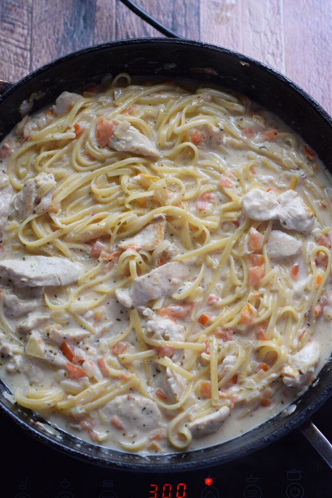 Cooking a creamy chicken and pasta dish.