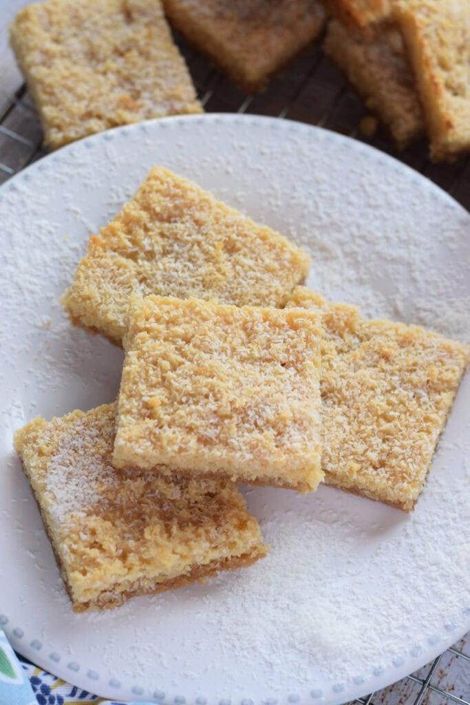 Chewy coconut bars on a white plate.