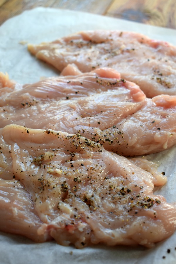 Seasoned chicken on parchment paper.