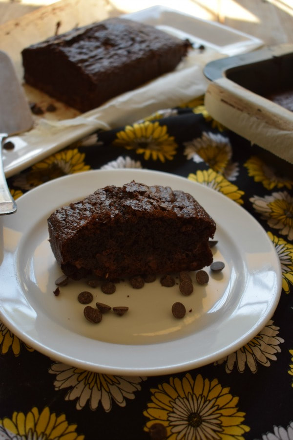 double chocolate loaf cake on a white plate with a sunflower placemat