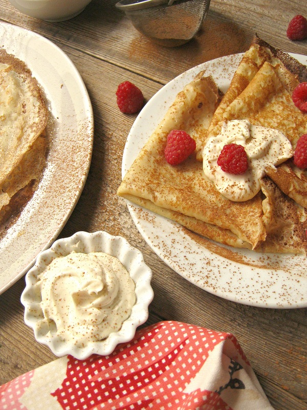 Cinnamon Crepes with Mascarpone Cream and Fresh Raspberries ona a wooden table