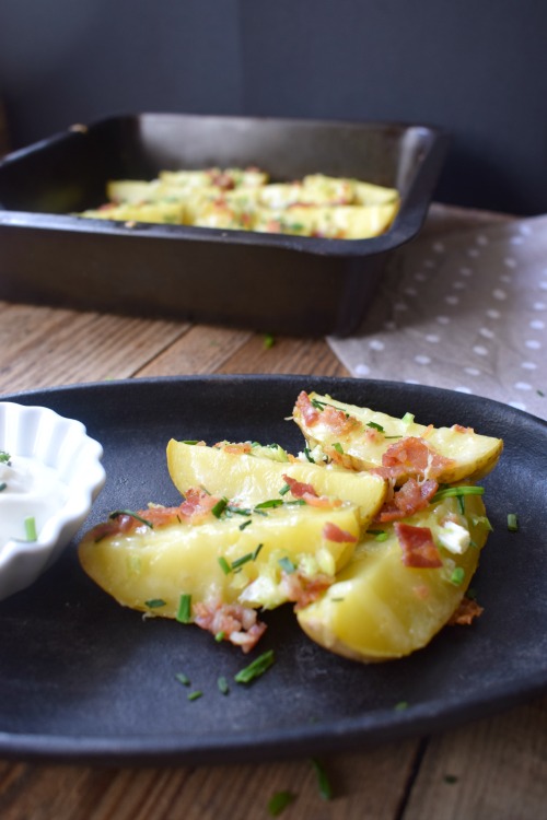 Cheese and bacon potato wedges with a black background