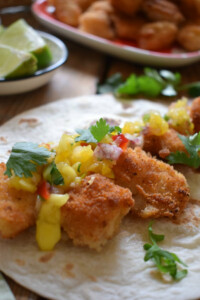 Fish tacos with a spicy mango salsa on a tortilla wrap.