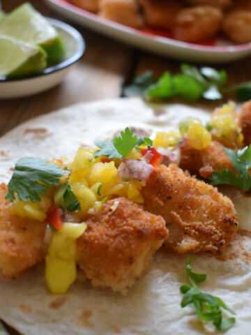 Fish tacos with a spicy mango salsa on a tortilla wrap.