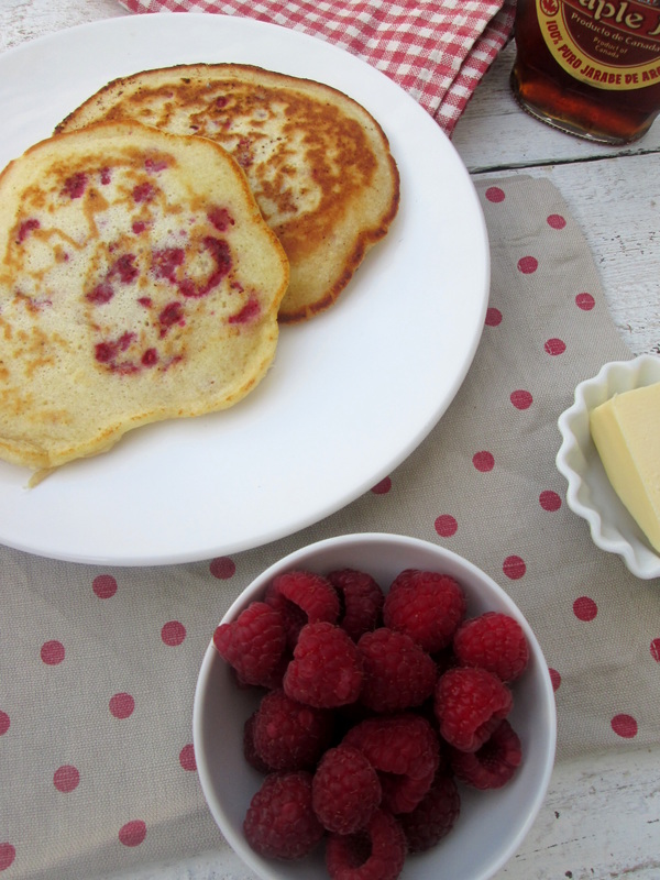 Fresh raspberry pancakes with berries on the side
