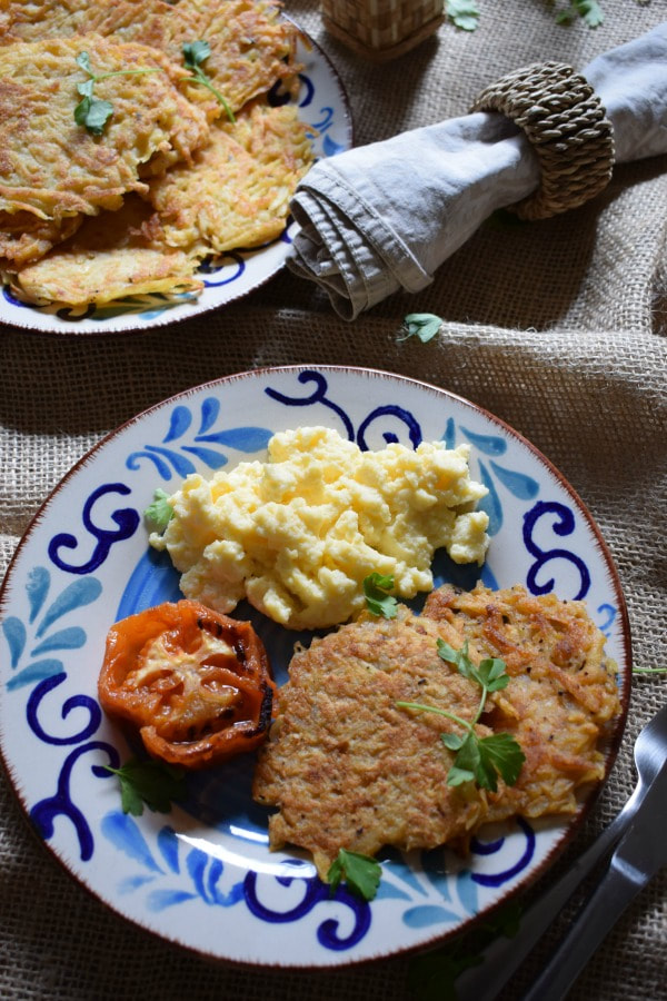 over head view of a breakfast setting with eggs, tomato and hash browns 