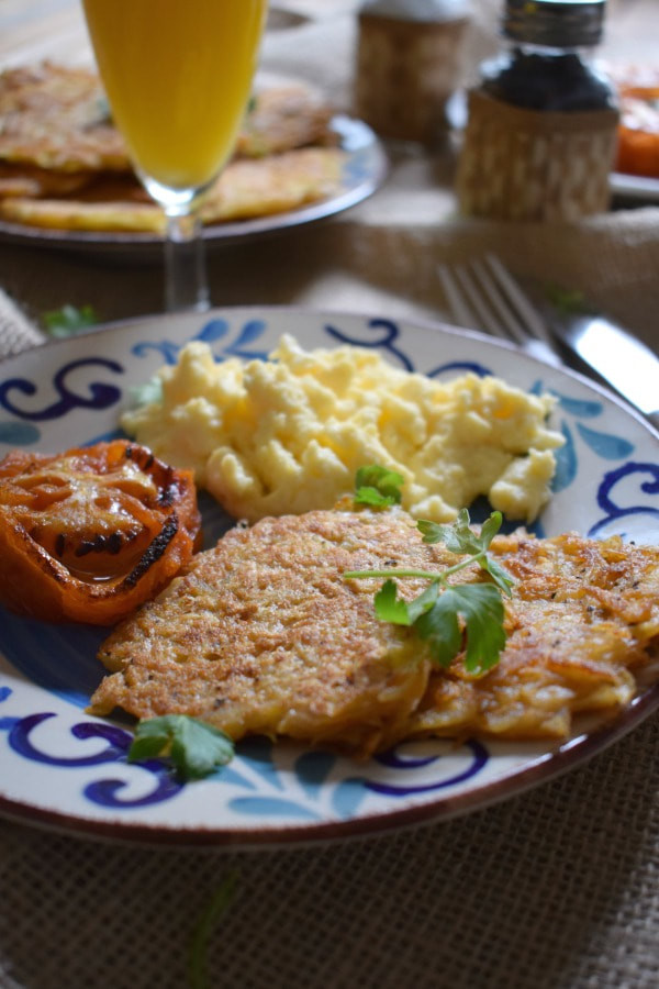 close up of hash browns, tomato and eggs