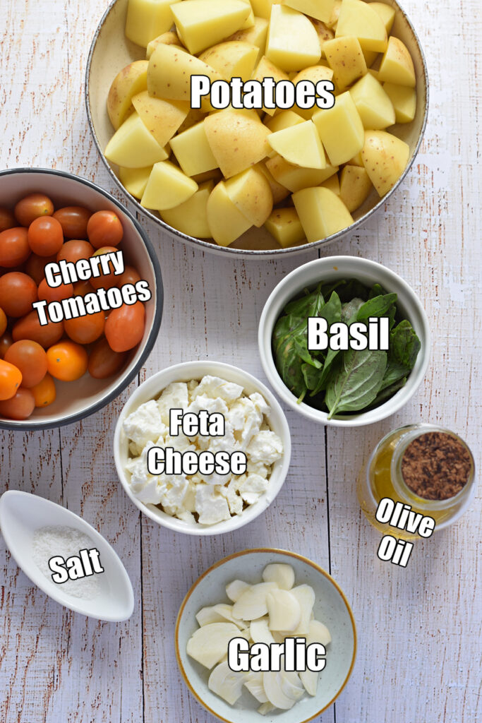 Ingredients to make potato and feta salad on a white table.