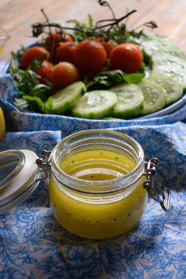 lemon vinaigrette in a jar with a fresh salad