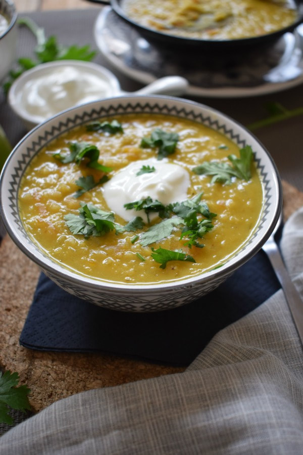 red lentil and coconut soup in a bowl with greek yogurt