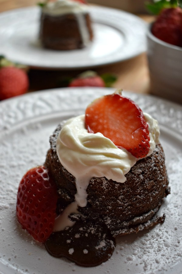 Close up of Molten Chocolate Lava Cakes with strawberries and cream
