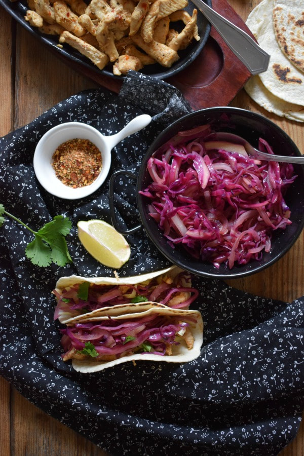 over head table setting view of teh Piri Piri Chicken Tacos with a Sauteed Red Cabbage Slaw
