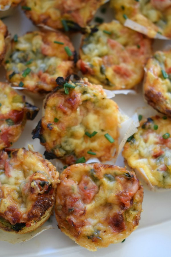Close up view of mini red pepper and spinach quiche.