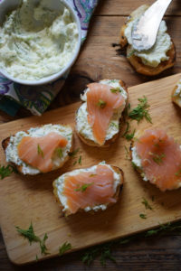 SMOKED SALMON CROSTINI ON A WOODEN BOARD