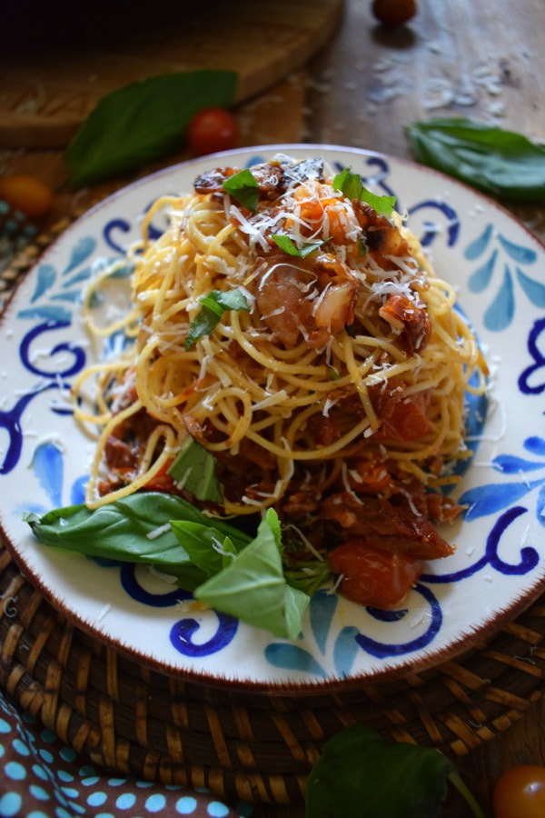 A pile of sun dried tomato and bacon spaghetti on a plate