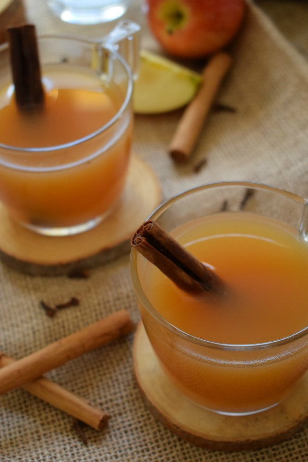 apple cider in glass cups with cinnamon sticks