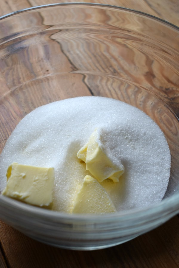 Butter and sugar in a glass bowl.