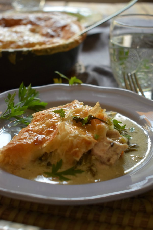 creamy chicken and vegetable pie on a plate with a glass of water