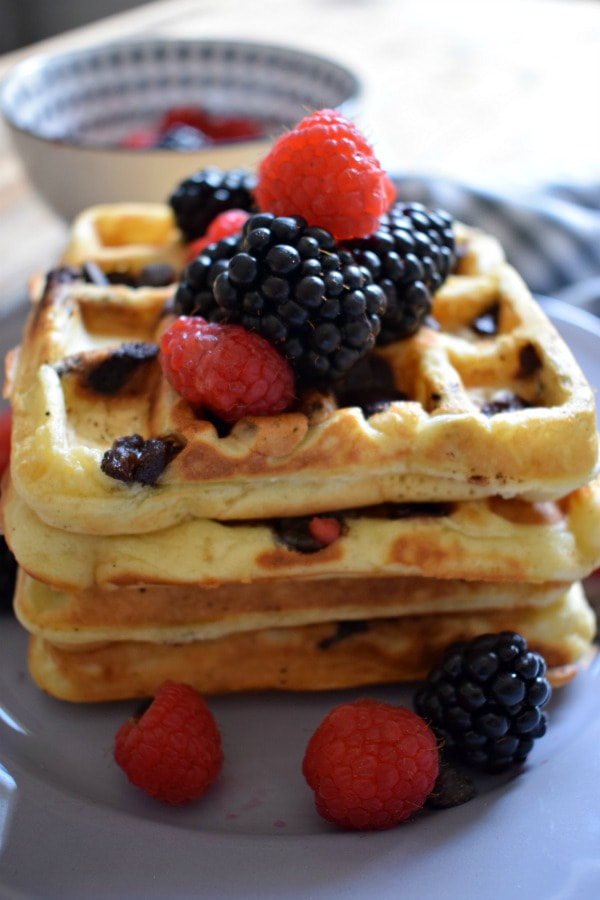 Stack of chocolate chip waffles with berries.