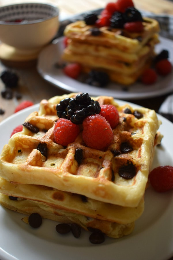 Stacks of chocolate chip waffles and berries.