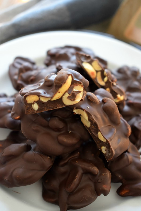 close up of chocoalte peanut cluster on a white plate
