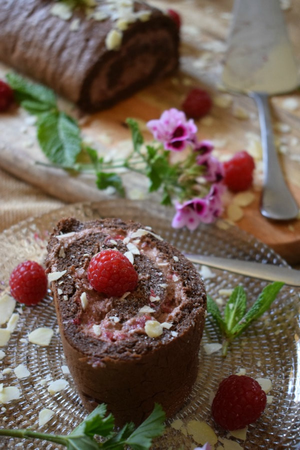 a slice of the Chocolate Raspberry Roulade  with the cake in the background