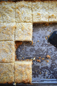 Chewy coconut bars in a baking tray.