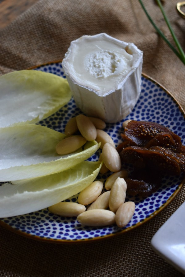 goat cheese, figs, almonds and lettuce on a blue plate