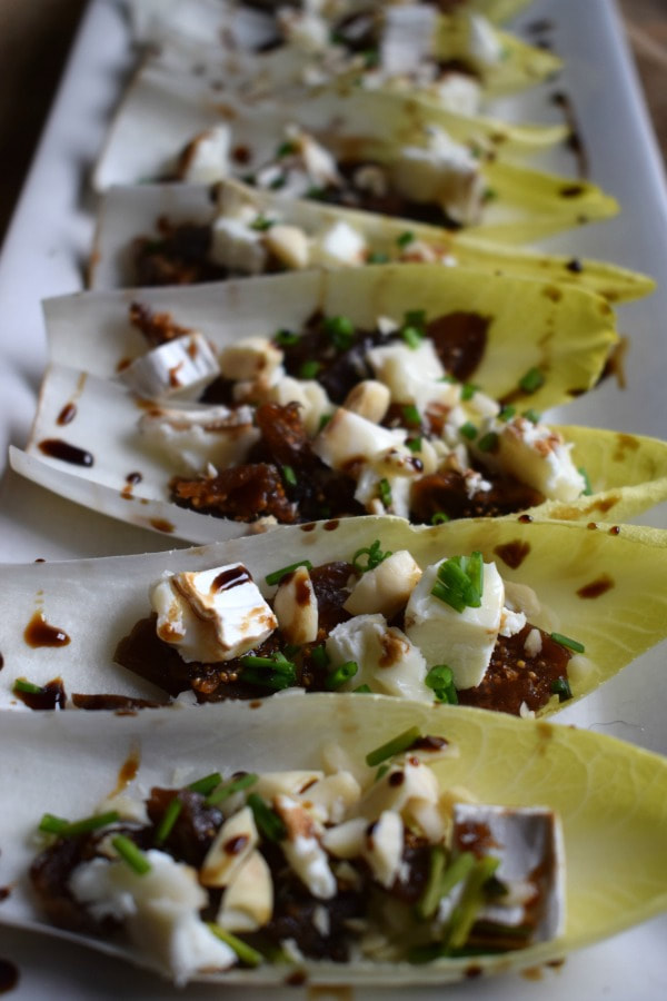 fig and goat cheese endive cups on a tray