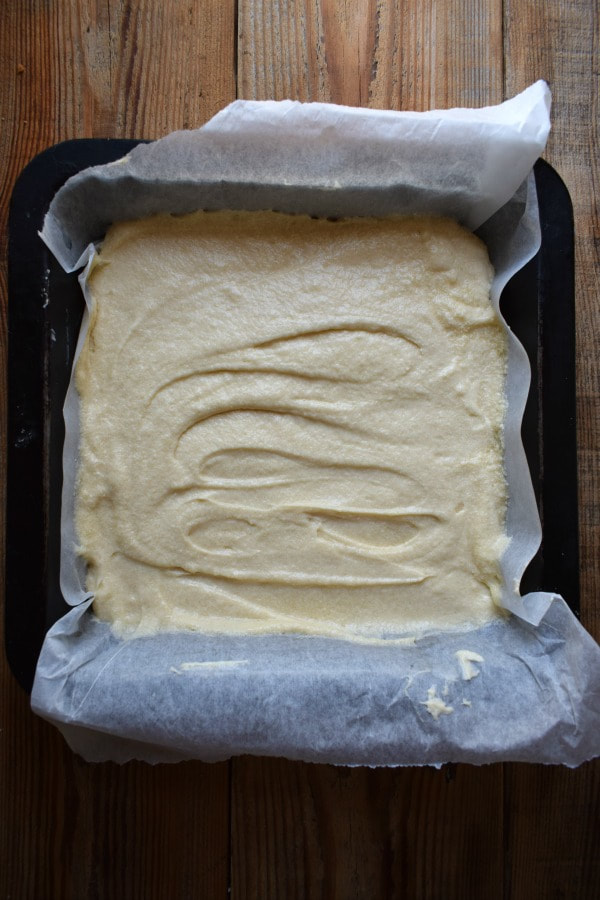 Cake batter in a square baking pan.