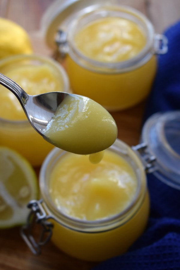 lemon curd on a spoon and in jars