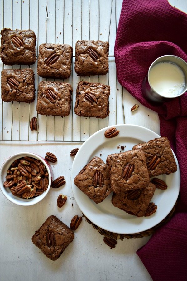 Table setting of the Chocolate Pecan Brownies with extra pecans and a cup of milk